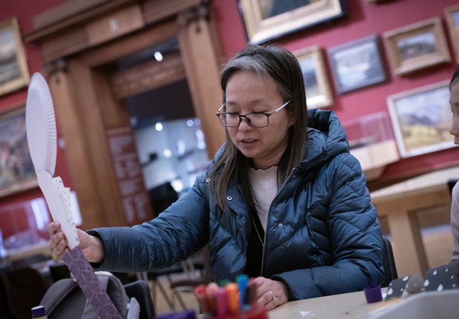 A person sitting at a table and taking part in a creative activity.