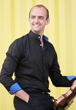 A man in a black button down shirt holding a violin