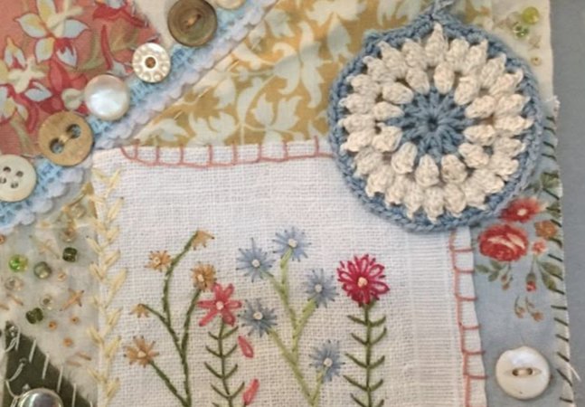 A variety of fabrics and button sewn together to form one piece of fabric.