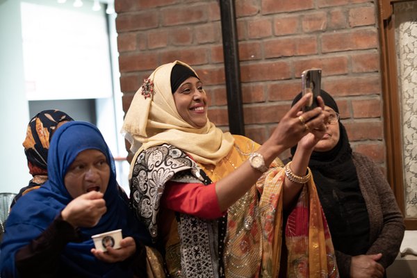 Women taking photos with phone at event Women taking photos with phone at event