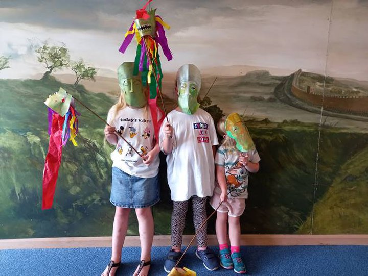 Three young children wearing handmade cavalry style masks