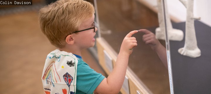Young boy pointing at object in a case