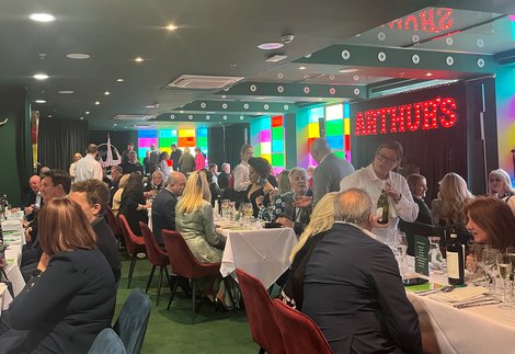 A room full of people seated at tables for a dinner