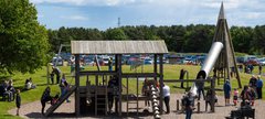 An outdoor playground with parents and children playing