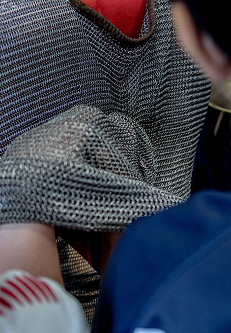 Replica chain mail tunic being worn by a child while two other children inspect the tunic