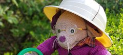 Great North Museum mascot Albany holds a magnifying glass