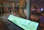 Illuminated map of Hadrian's Wall in a museum gallery with Roman artefacts