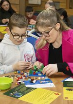 A adult and a child doing a LEGO activity. 