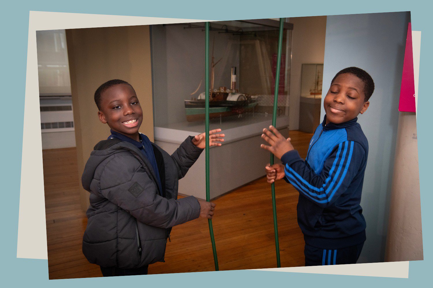 Two boys playing with a rope interactive in a museum.