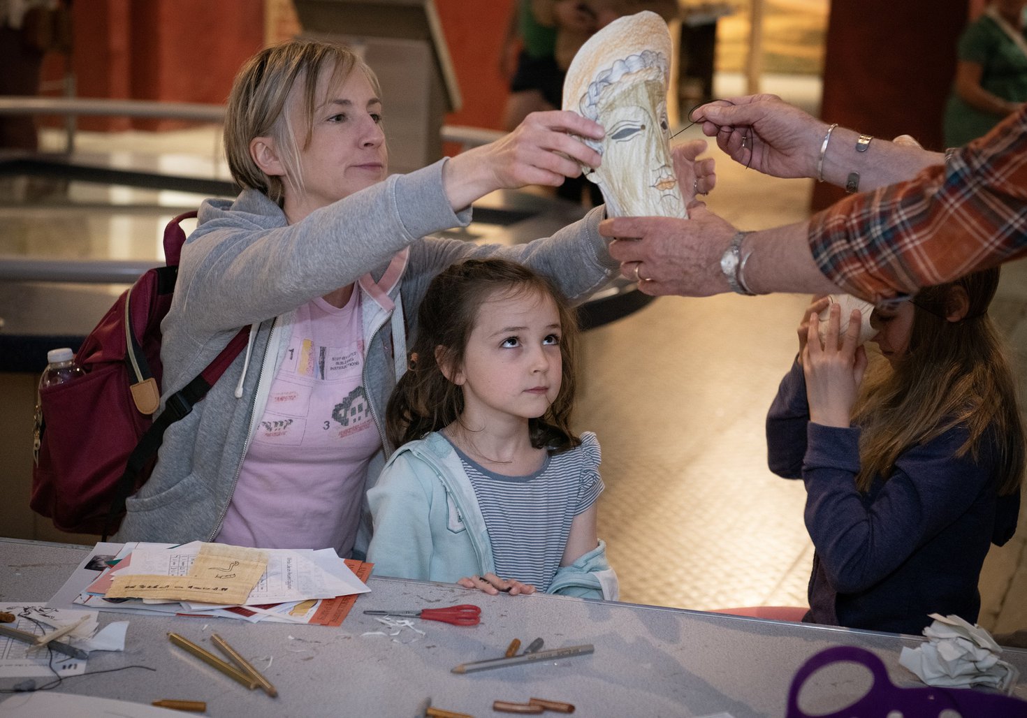 Woman helping to put mask on young girl
