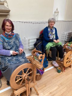 Two women sitting at spinning wheels