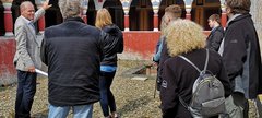 Man talks to group of people in the Roman reconstructions