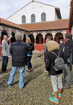 Man talks to group of people in the Roman reconstructions