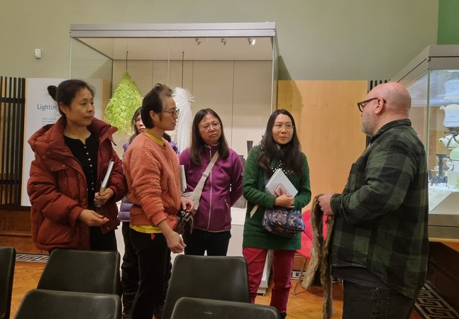 A group of people talking together in a gallery space