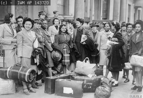 A group of West Indian women recruited to join the ATS, wait for transport to take them to their train© IWM AP 14372D