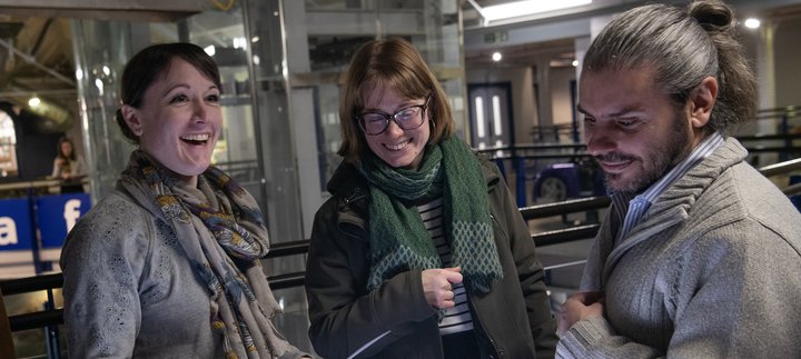 three people smiling in the museum at night
