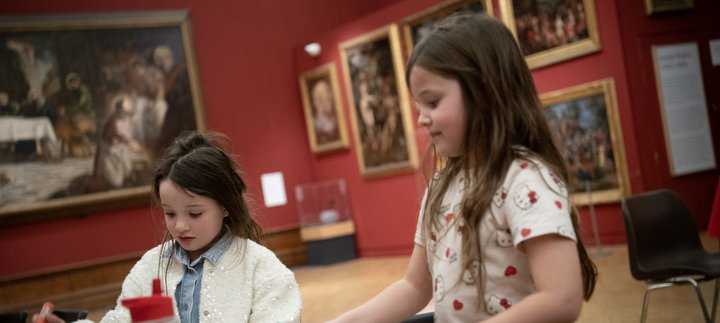 Two children taking part in a craft activity together.