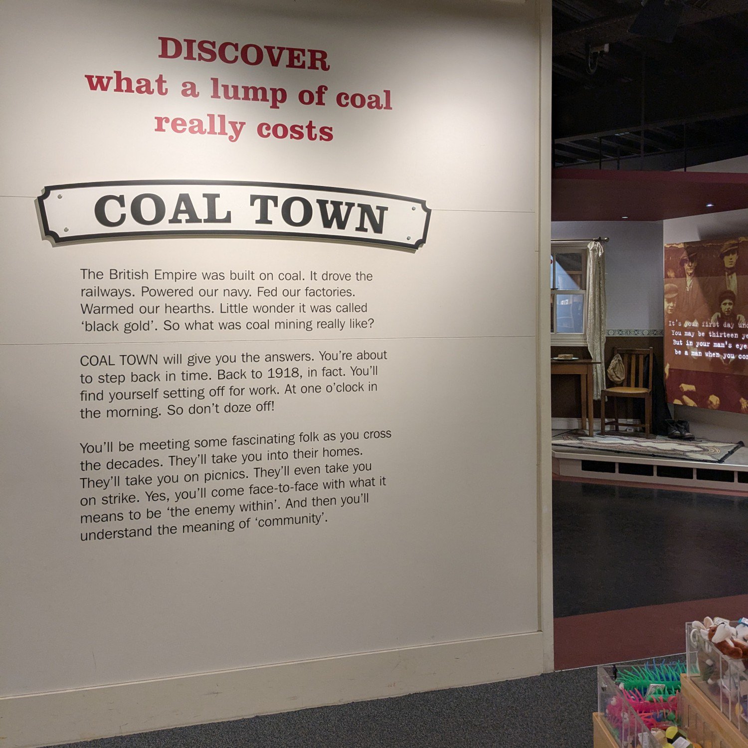 The first text panel of an exhibition called Coal Town. It says 'discover what a lump of coal really costs'.