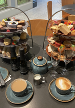 A photograph of three tiered afternoon tea with drinks