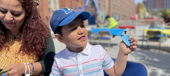 small boy in cap does craft on the plaza