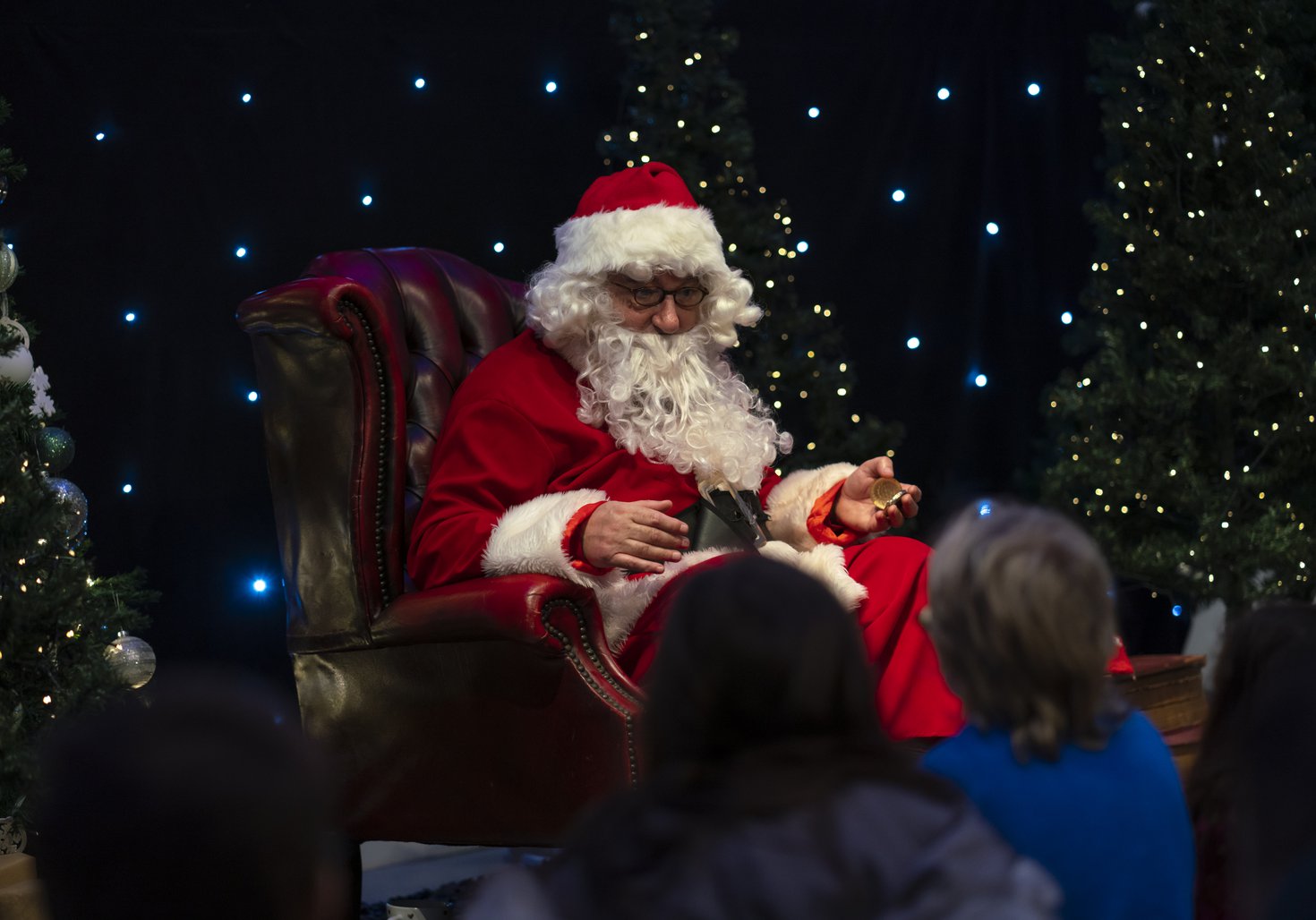 Children sat in front of a seating Santa as he reads to them at Woodhorn Museum
