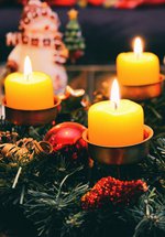 A Christmas table display of greenery and candles.