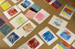 A photograph of a variety of prints made by children in fun, bright colours.