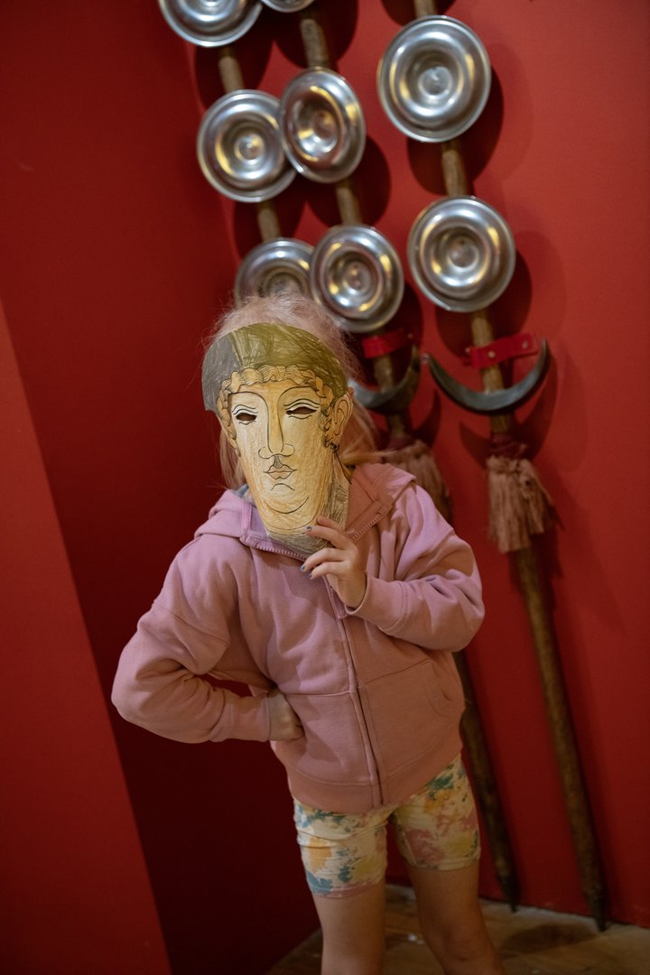 Child with mask in front of Roman standards