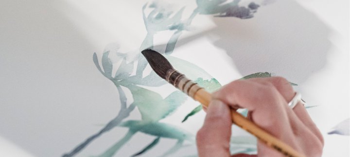 A hand painting a watercolour picture.