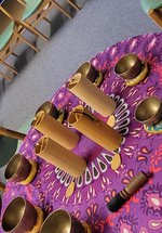 Musical instruments laid on a purple and yellow cloth on a table.
