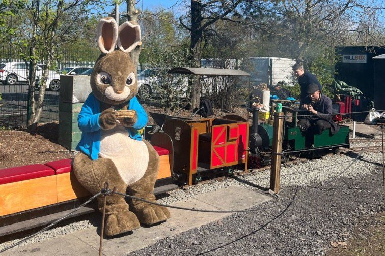 The Easter Bunny next to a miniature railway.