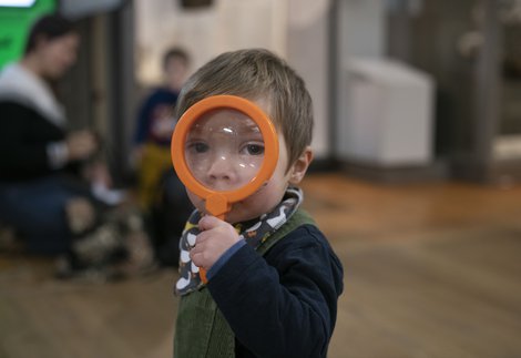 A toddler with a magnifying glass