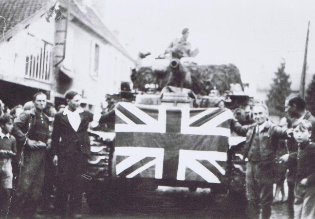 ‘Tank crew of the 13th/18th Hussars celebrating victory with the local population, 1945.’