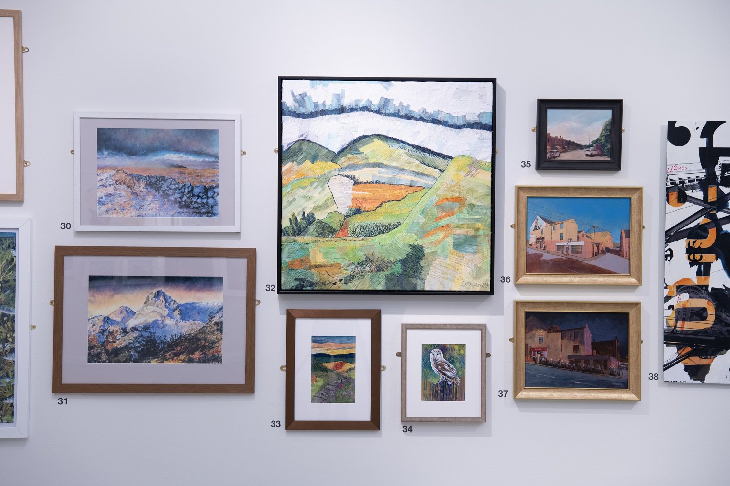 Paintings hung on a wall 'Salon' style.