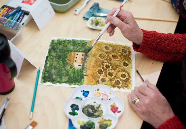 a photograph of a person painting a watercolour flower 