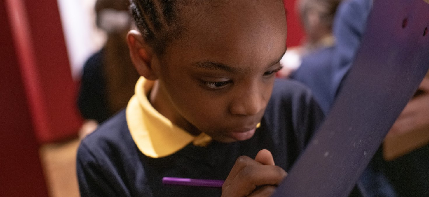 Child writing on clipboard