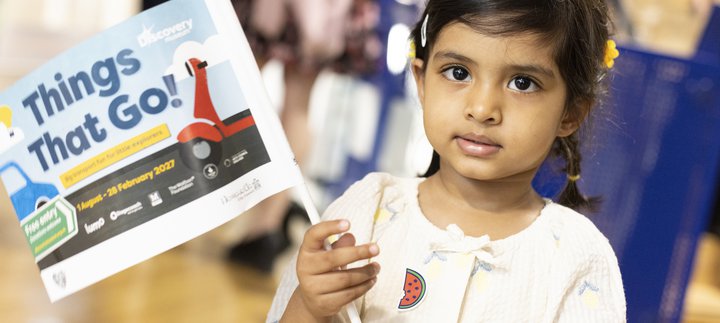 litle girl wavs flag in museum