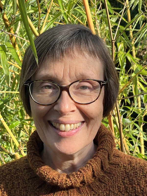 A person with short brown hair and dark rimmed glasses, smiling at the camera A person with short brown hair and dark rimmed glasses, smiling at the camera
