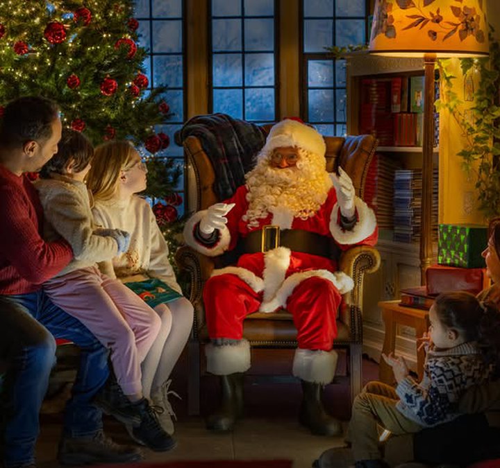 Father Christmas sat by the fire with children at the Hexham Old Gaol.