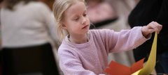 A girl with long blonde hair taking part in a craft activity