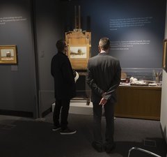 Two men looking at John Peace Artwork