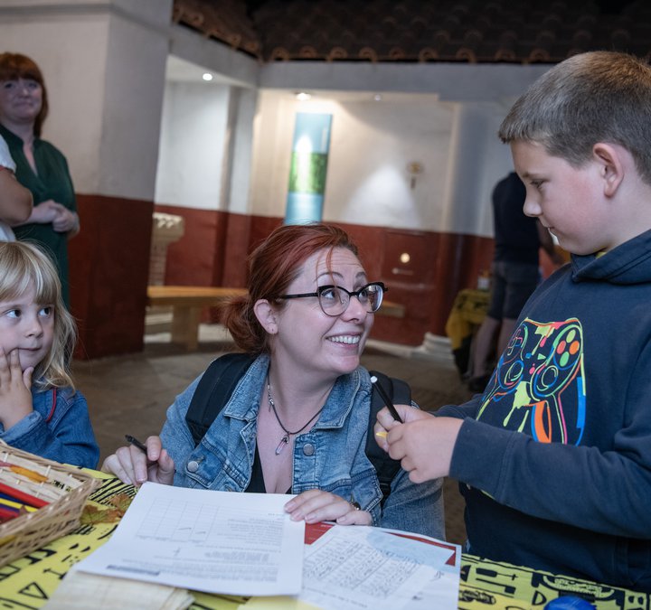 Young girl, mother, young boy doing craft activities