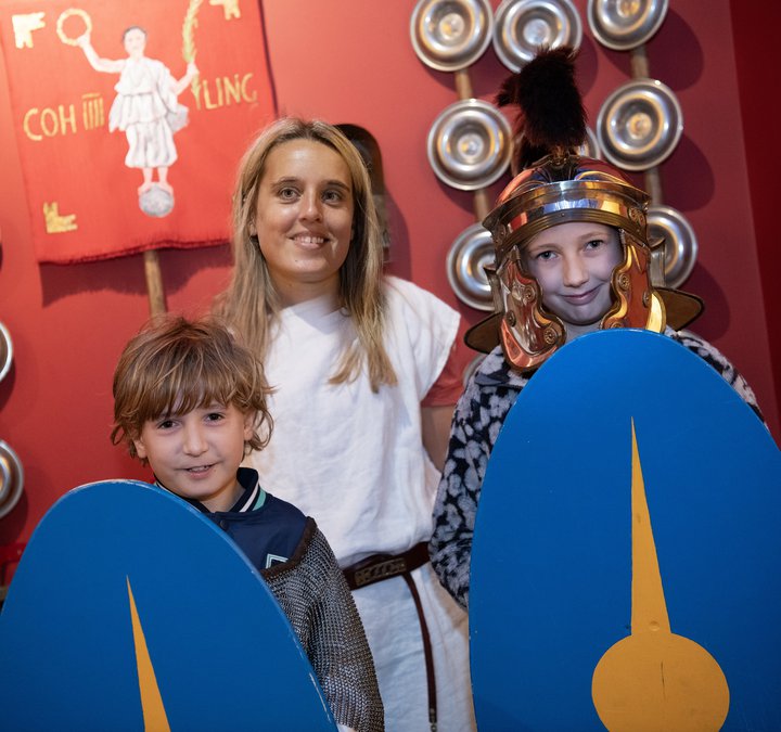 Two young children and an adult dressed as Romans