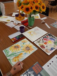 people doing watercolour painting round a table 
