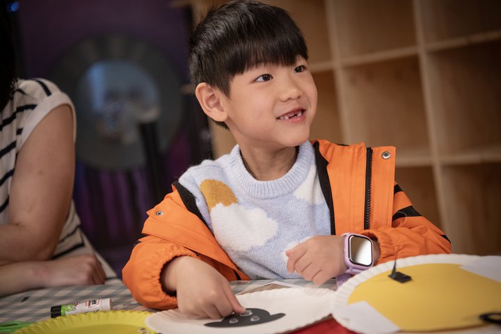 cheeky smiling boy doing craft