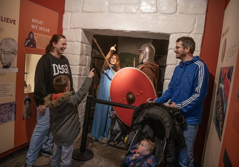 A family smiling and laughing in a museum display