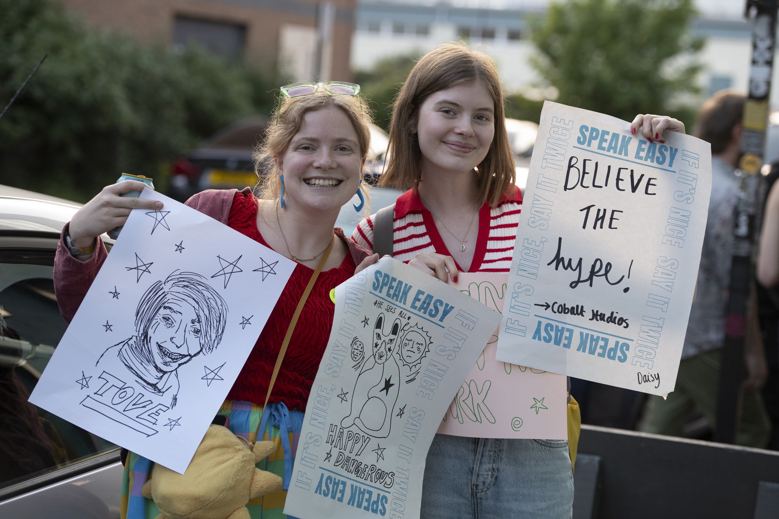 Two women showing posters they've made as part of a craft event.