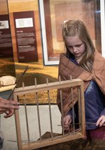 Woman and girl looking at model wattle fence