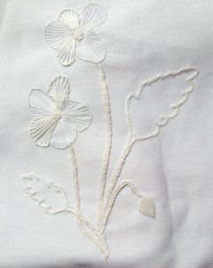 A white cotton fabric with white floral embroidery.