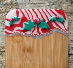 A photograph of a serving board with holly decorations.